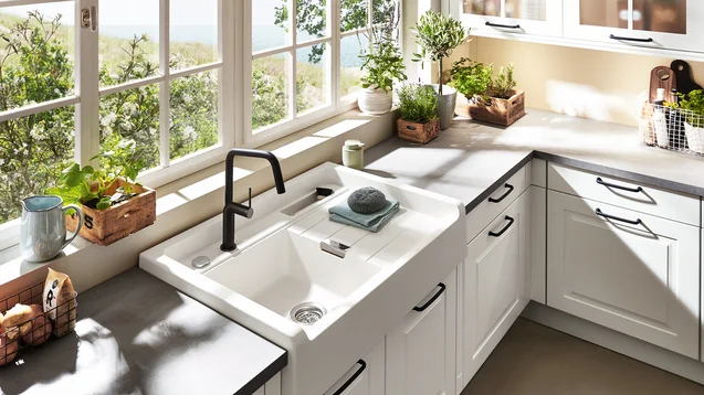 Cuisine en L style cottage blanc avec évier en céramique et vue sur jardin Cuisine en L style cottage blanc avec évier en céramique et vue sur jardin