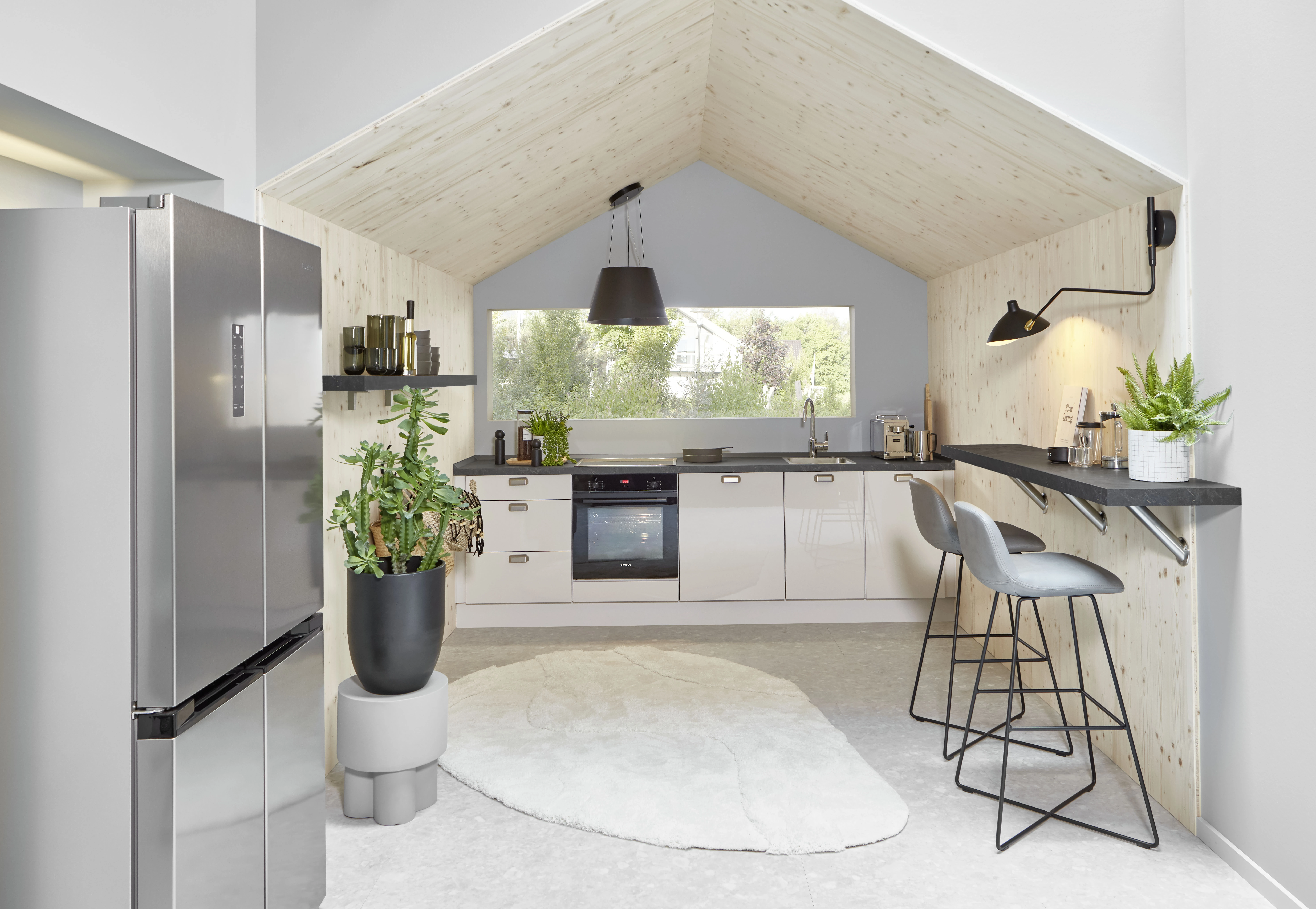 Cuisine équipée ouverte sous toiture bois avec bar et tabourets hauts Cuisine équipée ouverte sous toiture bois avec bar et tabourets hauts