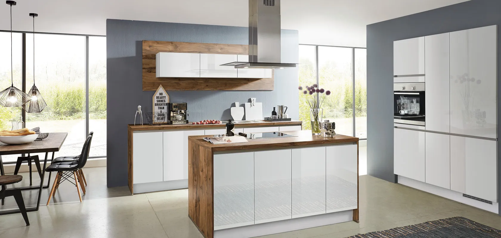 Cuisine avec îlot central blanc laqué et bois, hotte inox suspendue au plafond Cuisine avec îlot central blanc laqué et bois, hotte inox suspendue au plafond