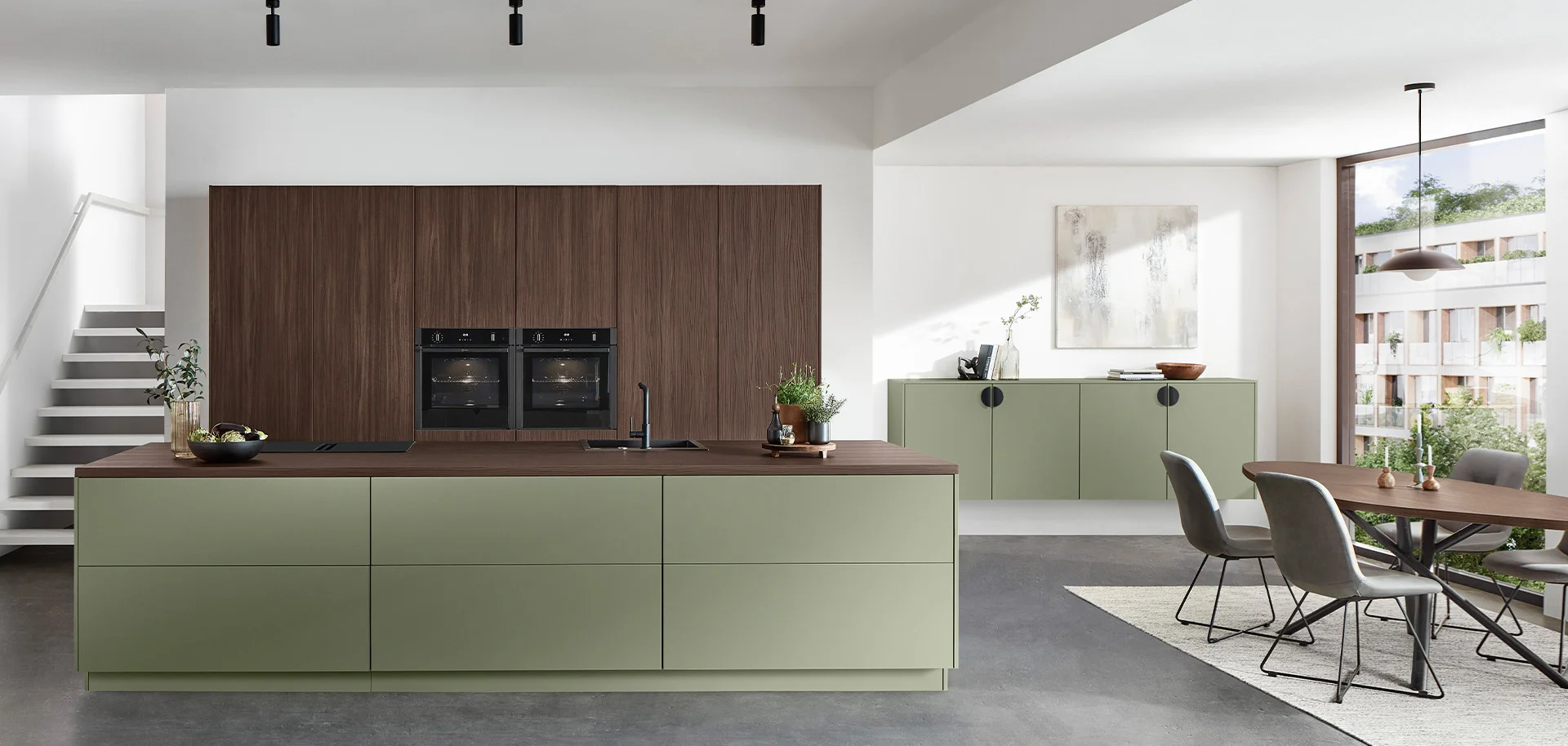 Cuisine ouverte avec grand îlot vert olive et façades bois foncé, salle à manger attenante Cuisine ouverte avec grand îlot vert olive et façades bois foncé, salle à manger attenante
