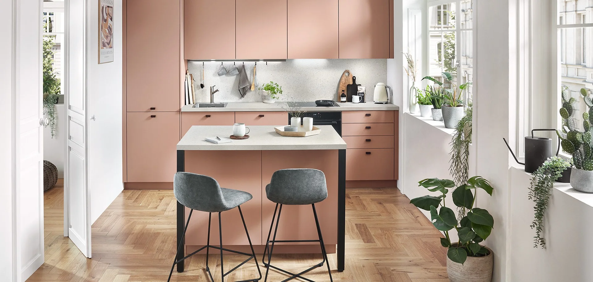 Cuisine linéaire rose poudré avec îlot central et chaises hautes grises Cuisine linéaire rose poudré avec îlot central et chaises hautes grises