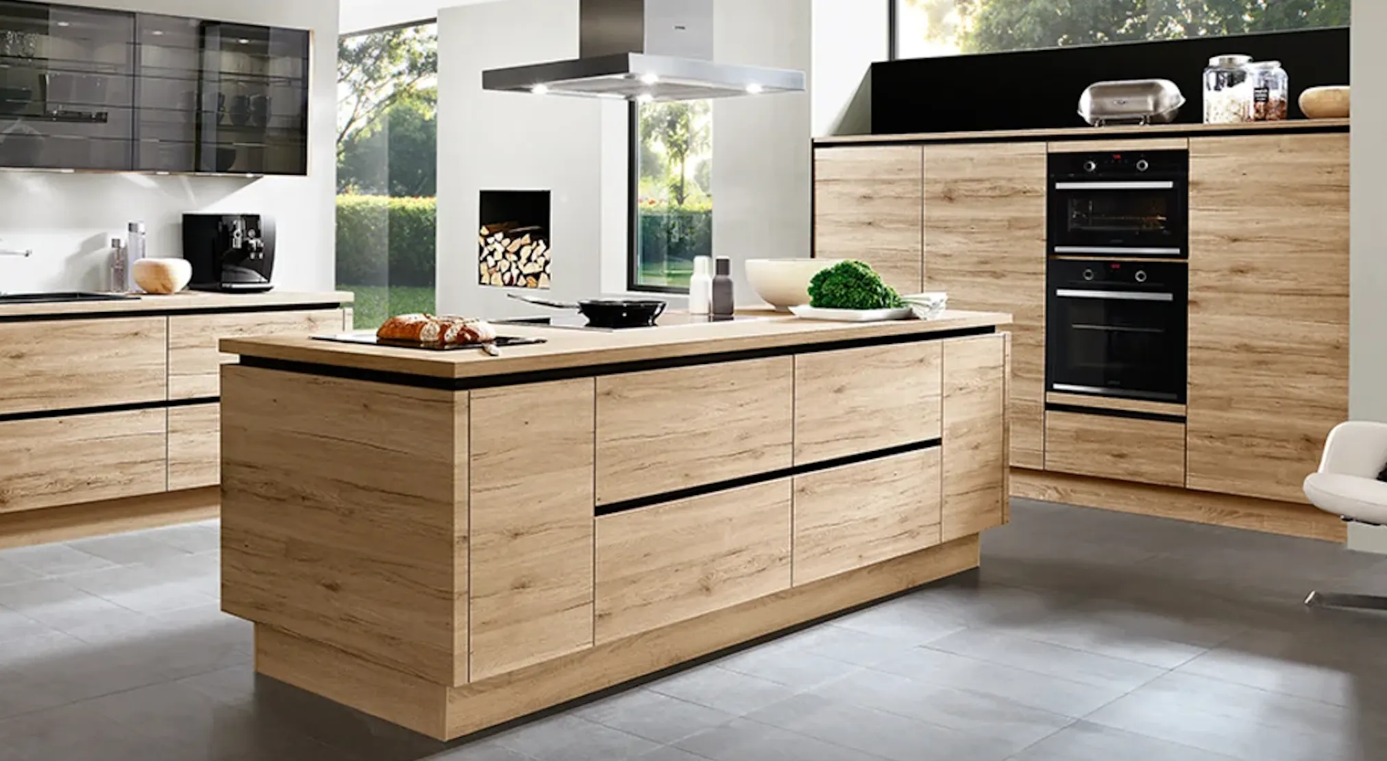 Cuisine ouverte matériau bois clair avec îlot central et plaque de cuisson intégrée Cuisine ouverte matériau bois clair avec îlot central et plaque de cuisson intégrée