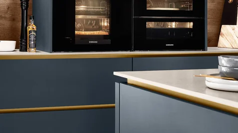 Cuisine teinte profonde bleu marine avec fours Samsung encastrés et finitions dorées Cuisine teinte profonde bleu marine avec fours Samsung encastrés et finitions dorées
