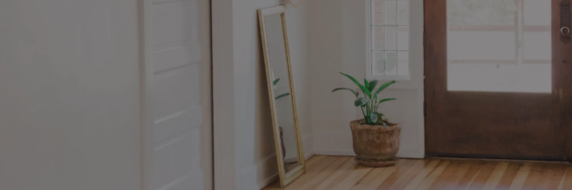 Entrée de maison lumineuse avec miroir sur pied et porte vitrée en bois Entrée de maison lumineuse avec miroir sur pied et porte vitrée en bois