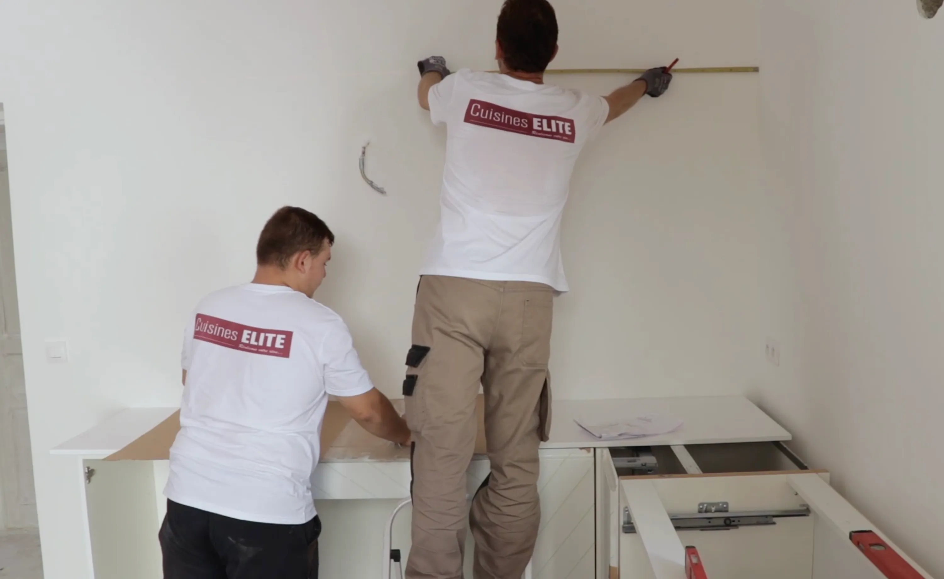 Poseurs Cuisines Elite prenant des mesures au mur avant installation de meubles de cuisine Poseurs Cuisines Elite prenant des mesures au mur avant installation de meubles de cuisine
