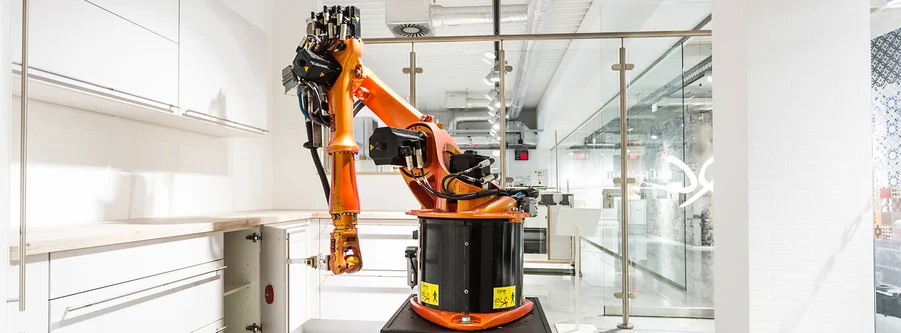 Bras robotisé testant la durée de vie et la résistance des meubles de cuisine en laboratoire Bras robotisé testant la durée de vie et la résistance des meubles de cuisine en laboratoire