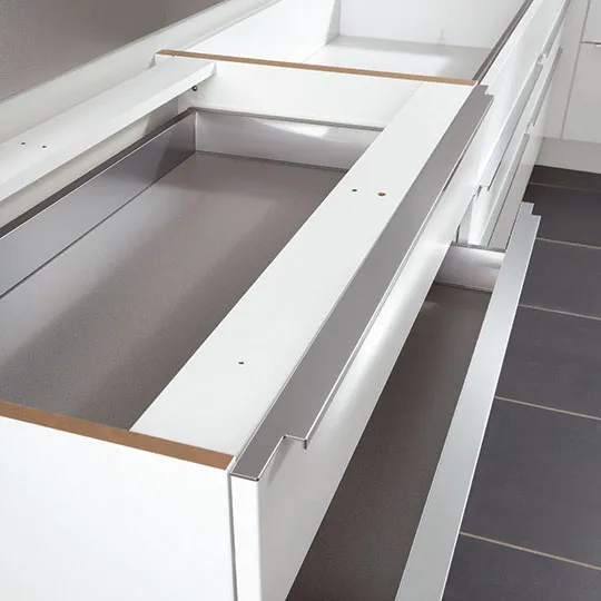 Gros plan sur un tiroir de meuble de cuisine Cuisines Elite ouvert, structure blanche renforcée Gros plan sur un tiroir de meuble de cuisine Cuisines Elite ouvert, structure blanche renforcée